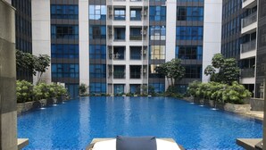 A swimming pool with a lounge chair and a small waterfall feature.
