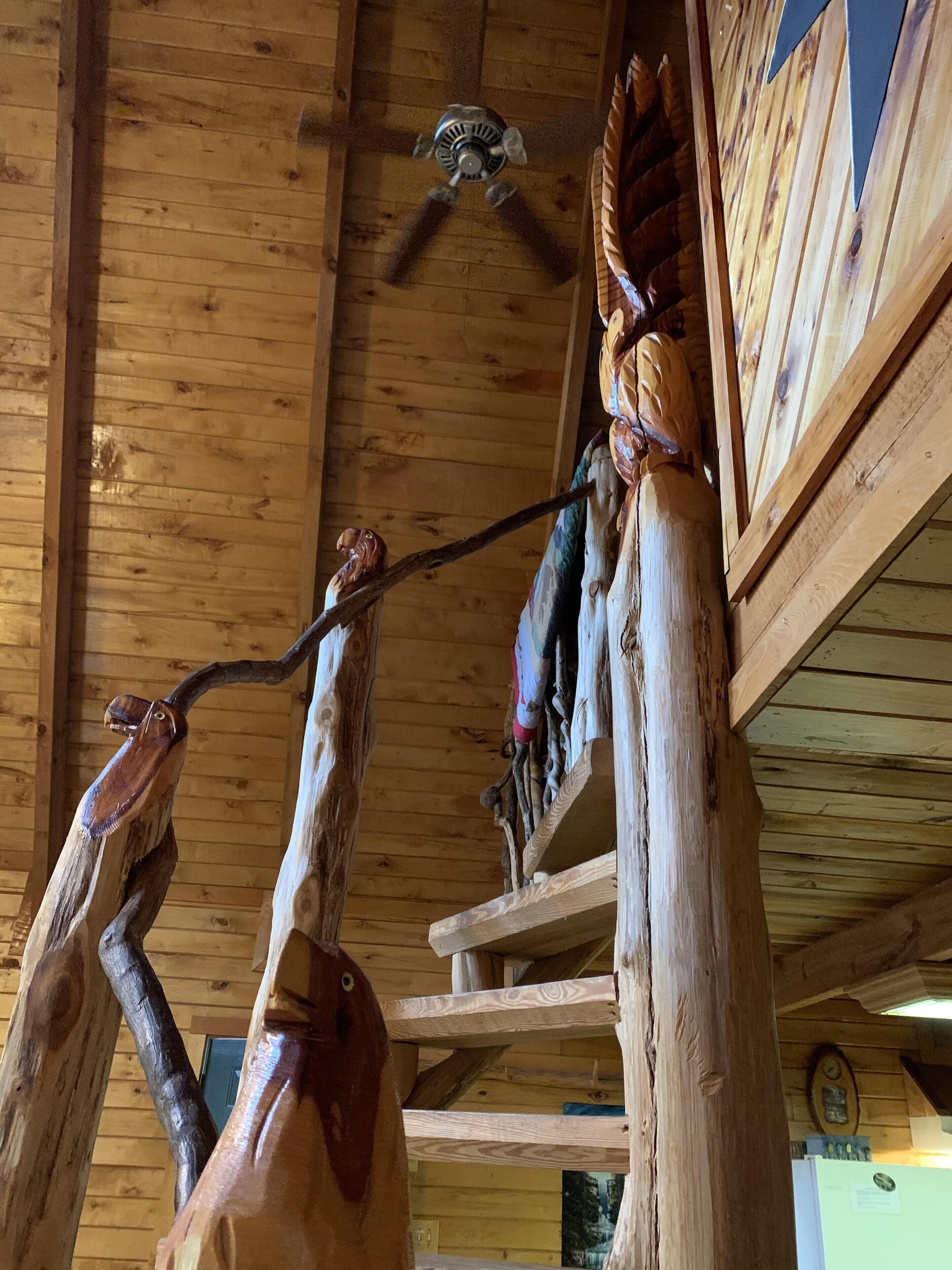 A wooden ceiling with a ceiling fan, wooden beams, and a rustic interior design.