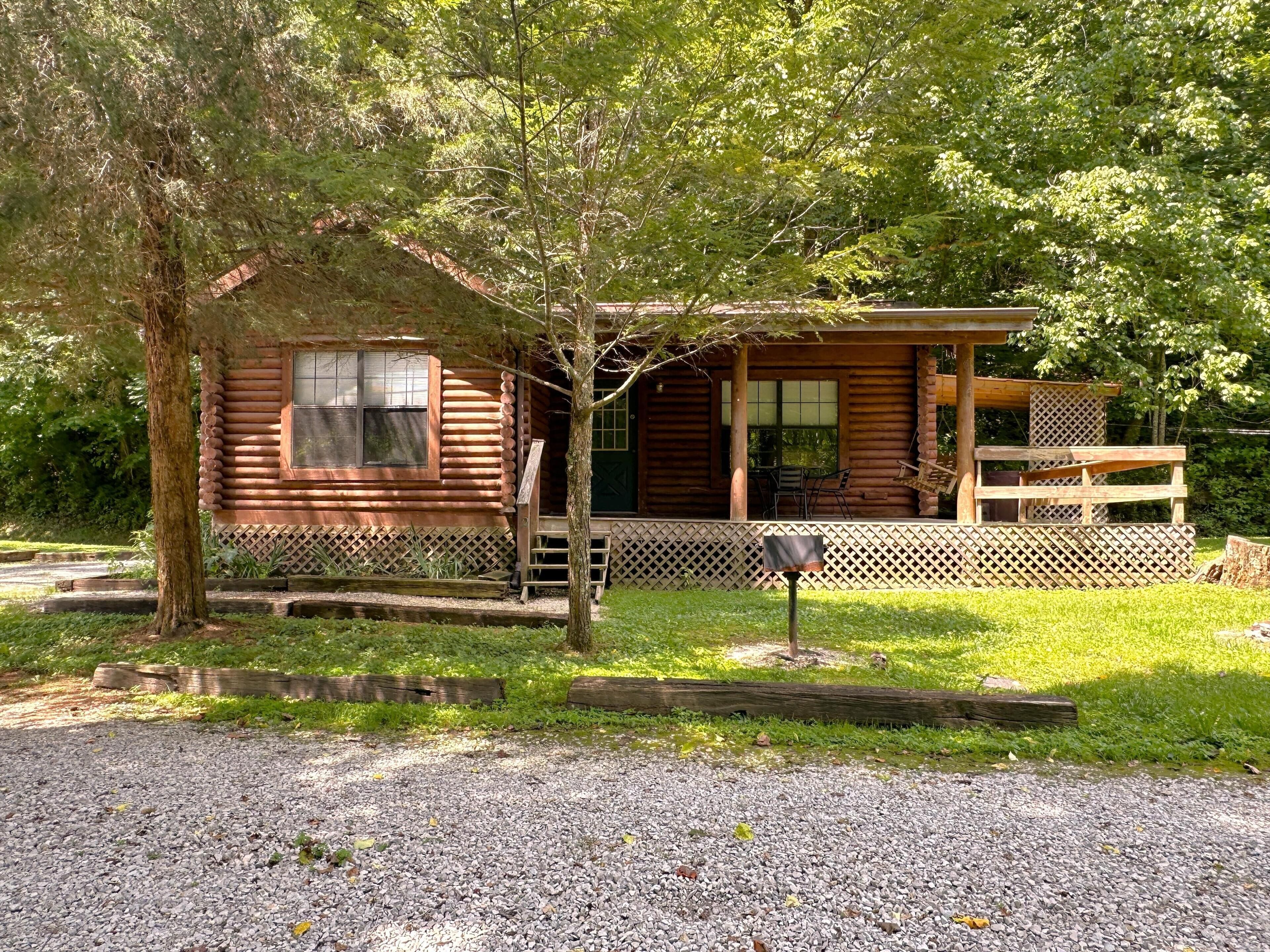 Une cabane en bois avec une véranda, une fenêtre et une porte.
