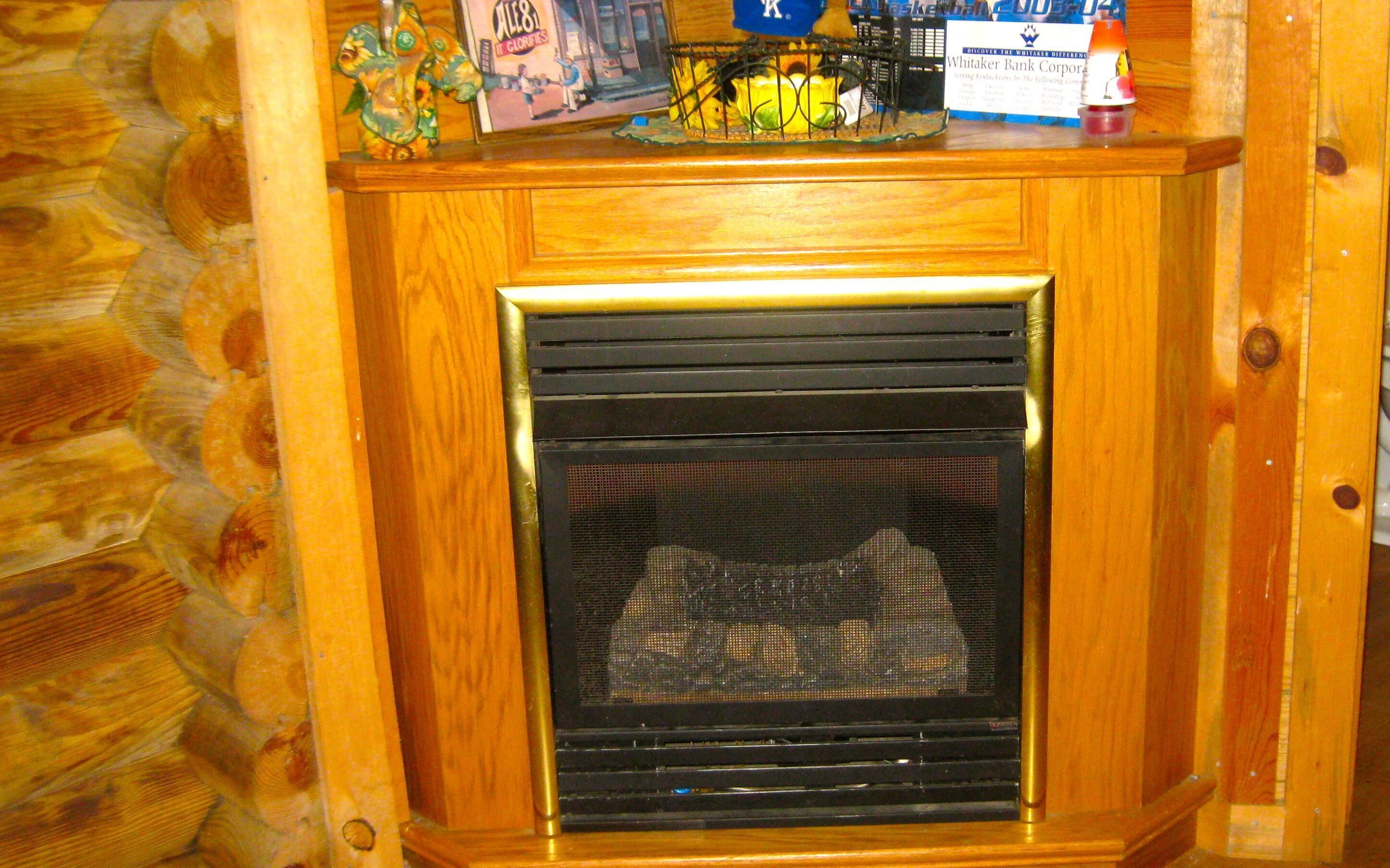 A wooden fireplace with a glass door, surrounded by a wooden wall.