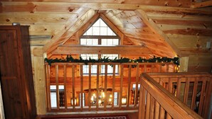 A wooden cabin with a loft bedroom, a wooden staircase, and a view of the surrounding landscape. - Spacious cabin with Hot Tub and wood burning fireplace and wi-fi (Campton)