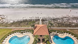 A resort with a large pool, a beach view, and a fenced area. - Gulf Views & Pool Access: Coral Reef Resort Condo (Panama City Beach)