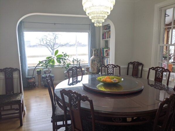 A dining area with a round table, chairs, a chandelier, and a view of the outside. - Riverside Home Minutes to Casino, Downtown, Bridge, UWindsor (Windsor)