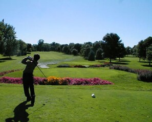 Golfers can enjoy a well-manicured green and beautiful flower beds.