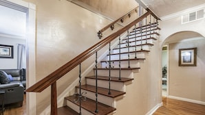 Eine Treppe mit Holzstufen und Metallgeländern, die zu einer oberen Etage führt.