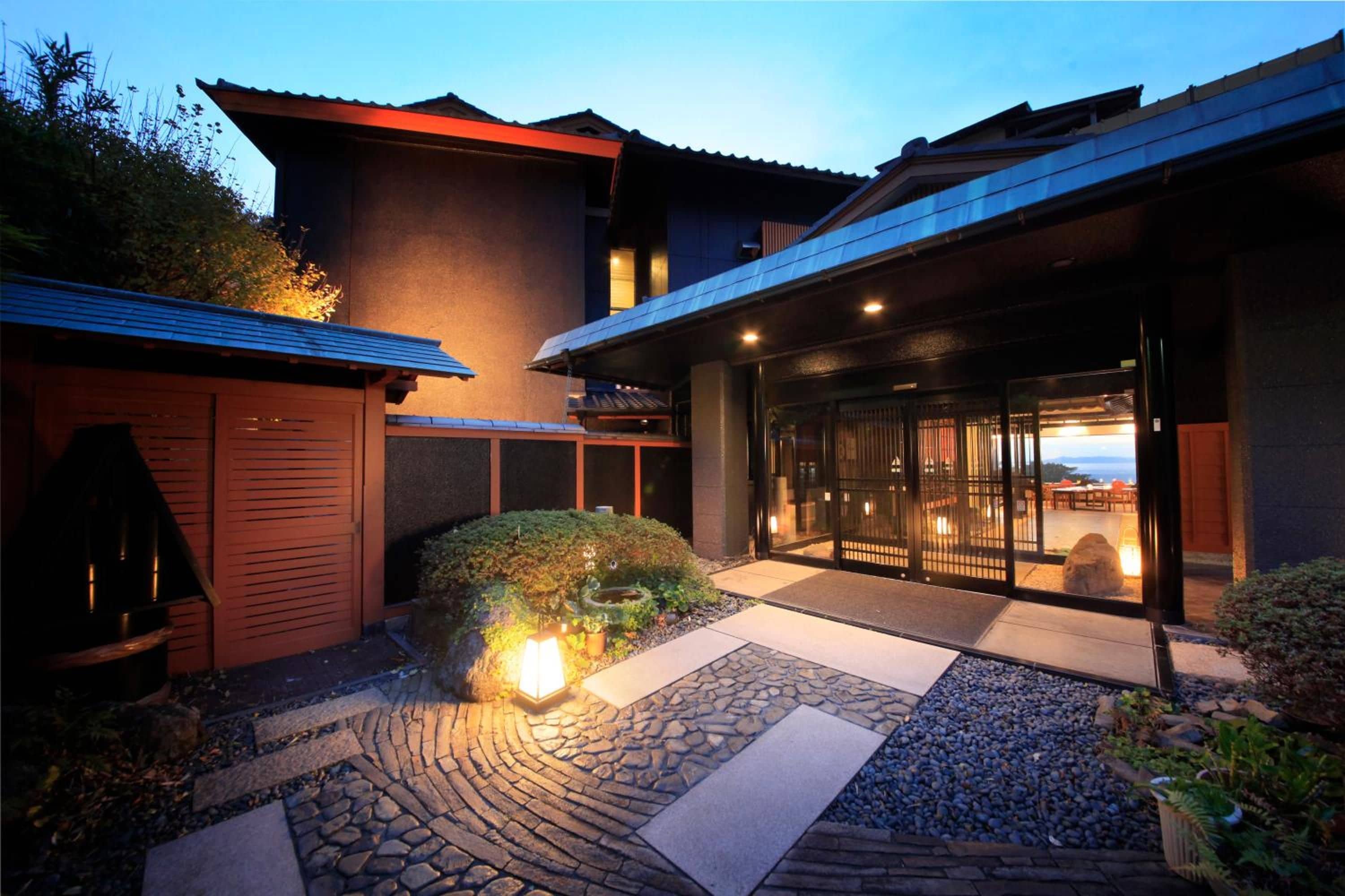 A modern building with a stone pathway leading to a glass door entrance.