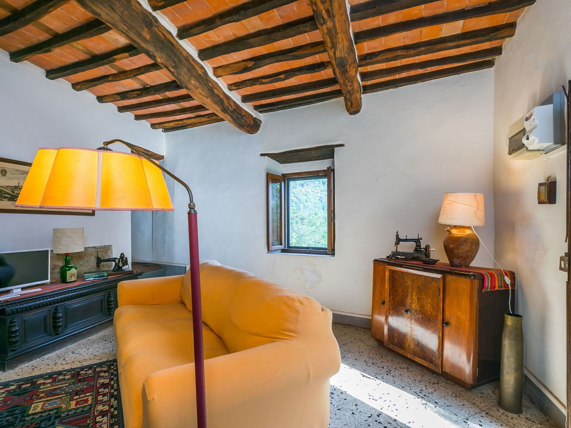 A cozy living room with a yellow armchair, a wooden cabinet, and a sewing machine.