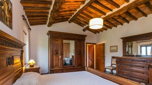 Un dormitorio con una cama grande, un armario de madera y un espejo.