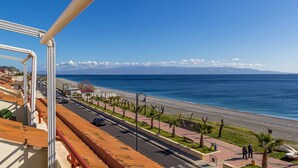 A coastal road with a pedestrian path, beach, and distant mountains. - La Plage - Home and Sea (Nizza Di Sicilia)