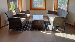 A room with a corner sofa set, a coffee table, and large windows with blinds. - Under Hill Pension (Pyeongchang)