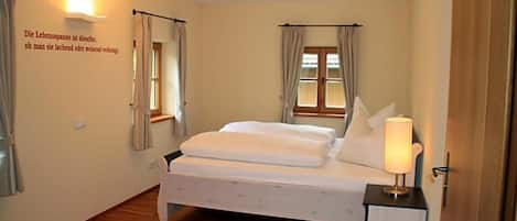 Une chambre à coucher avec un lit, une table de chevet avec une lampe et un luminaire fixé au mur.