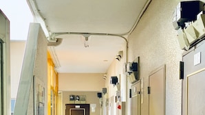 A corridor with doors on both sides, a fire extinguisher, and a door labeled "1K". - Hostel 758 Nagoya 4P (Nagoya)