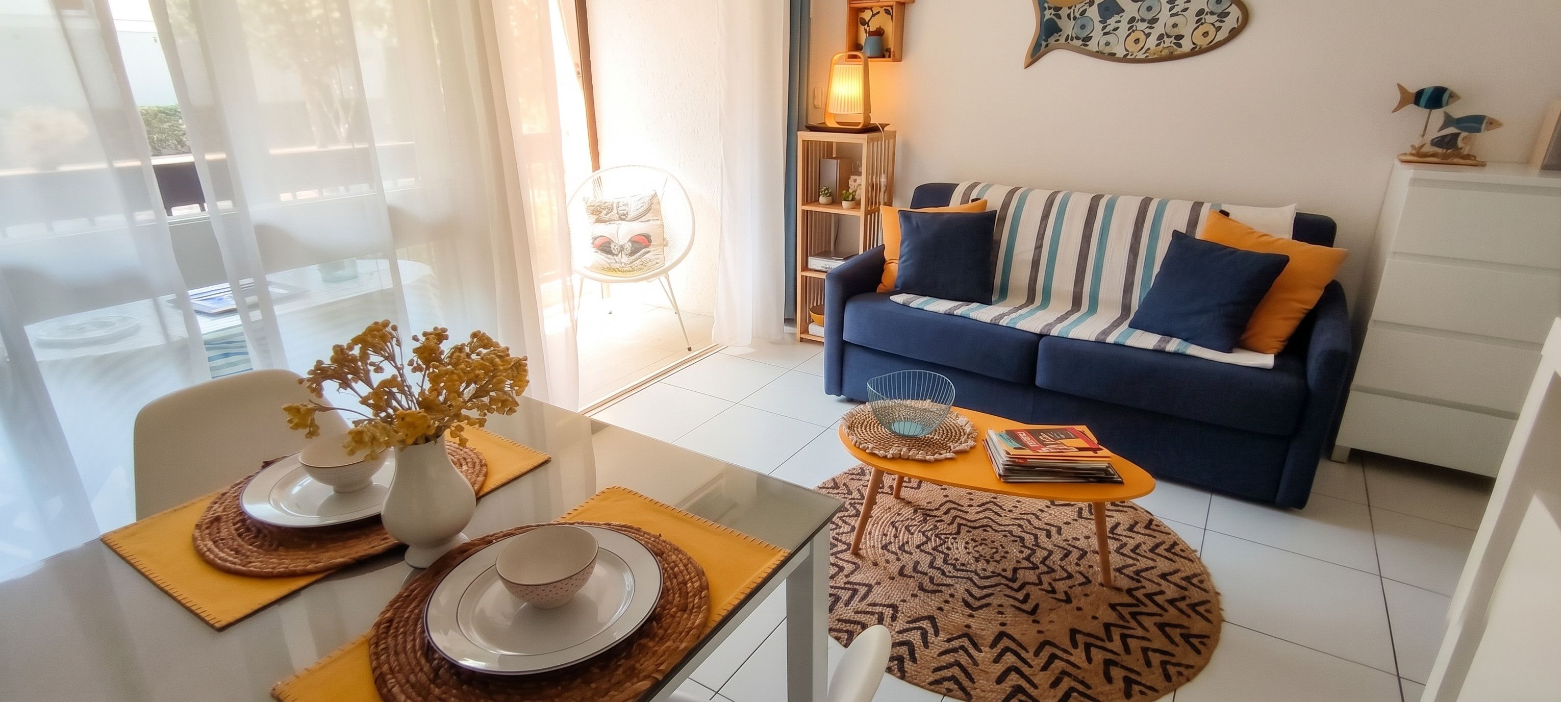 Un salon moderne avec un canapé, une table basse et une table à manger agrémentée de sets de table.