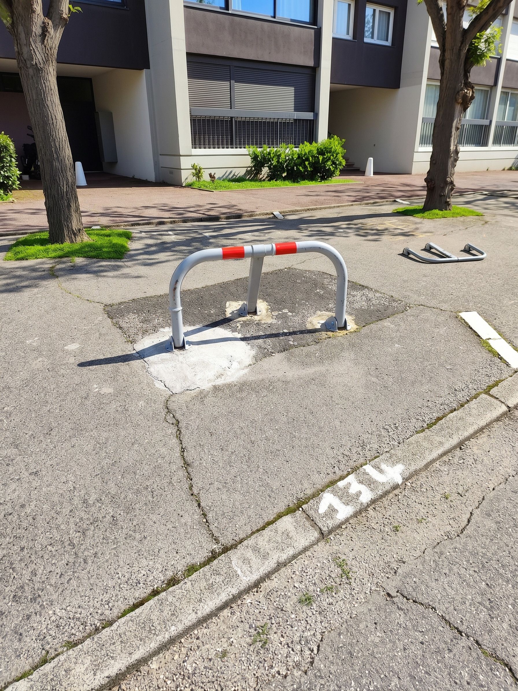 Ein Parkplatz mit einer Metallsperre und einer weißen Linie, die den Stellplatz markiert.