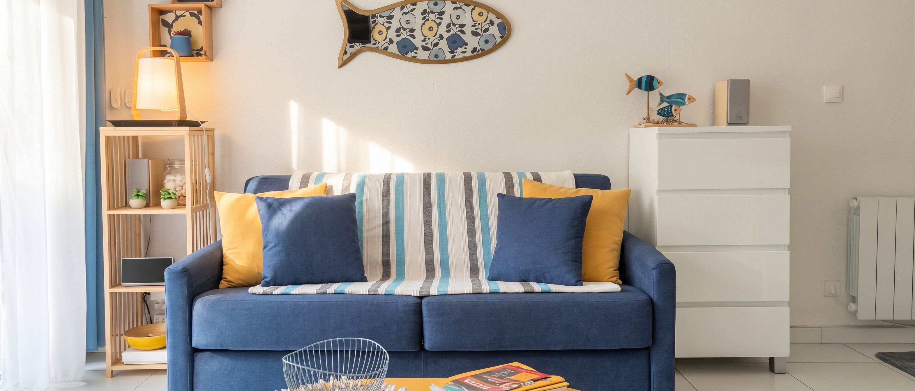 A living room with a sofa, a side table, a bookshelf, and a radiator.