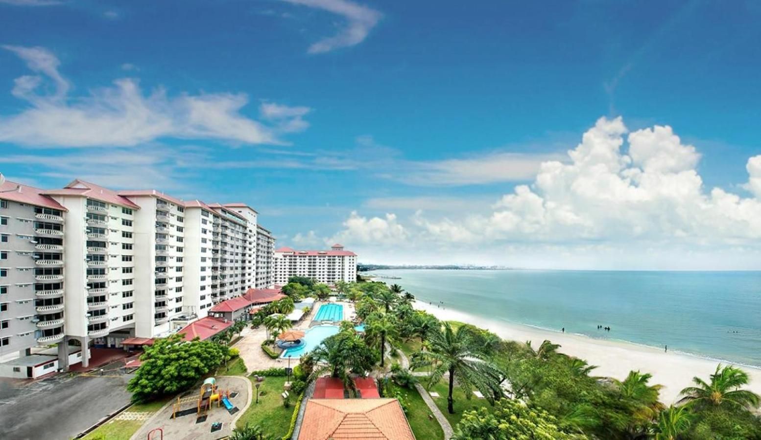 Un hôtel à plusieurs étages, doté d’une piscine et offrant une vue sur la plage.