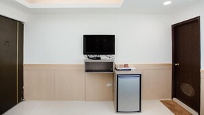 A room with a flat-screen TV mounted on the wall, a small cabinet below it, and a compact refrigerator. - Taipei 101 Yurmans House (Taipei)