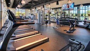 Een sportschool met loopbanden, gewichtapparaten en gewichten.