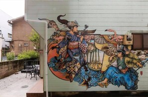 A mural on a building's exterior featuring traditional figures and a musical instrument. - Nishi shinjyuku wa-an homestay (Tokyo)