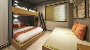 Une petite pièce avec des lits superposés, un bureau et une fenêtre avec des stores.