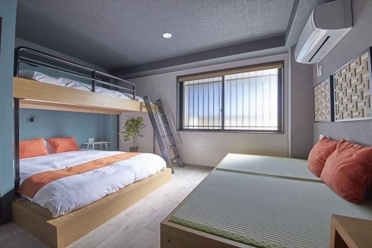 A bunk bed room with a desk and a window.