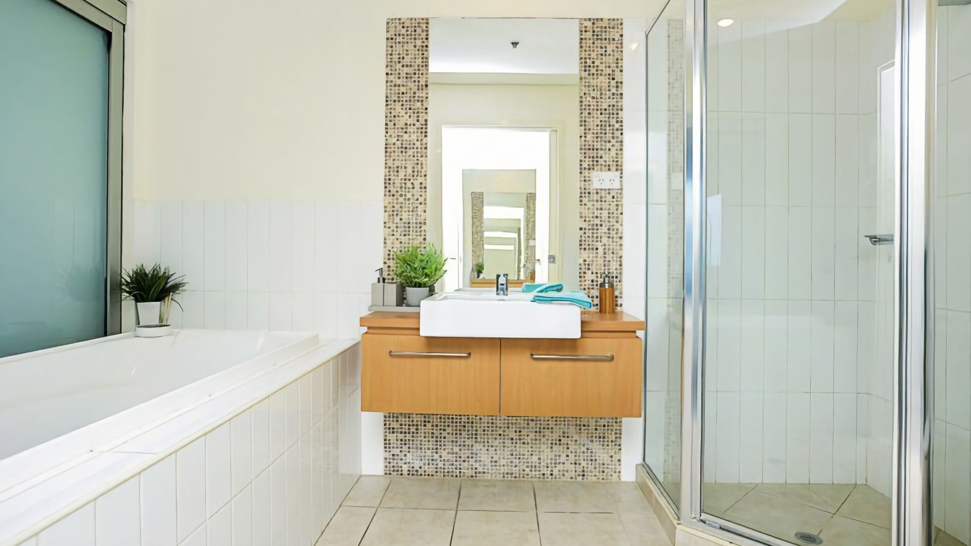 A modern bathroom with a bathtub, a sink with a mirror, and a shower area.