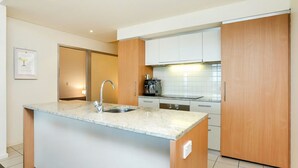 Una cocina moderna con una isla central, electrodomésticos de acero inoxidable y armarios de madera.