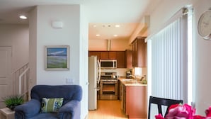 Una cocina moderna con electrodomésticos de acero inoxidable, armarios de madera y vistas al área de estar.