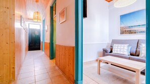 A hallway with wooden walls, a tiled floor, and a seating area with a sofa and a table. - TREM HOUSE - LOCATED IN OLD CITY - FARO (Faro)
