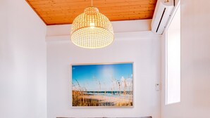 A cozy living room with a wooden ceiling, a brown sofa with patterned cushions, a wooden coffee table, and a beach-themed painting on the wall. - TREM HOUSE - LOCATED IN OLD CITY - FARO (Faro)