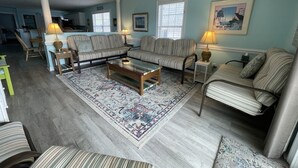 A living room with striped sofas, a coffee table, and a patterned rug. - Come On In (Downstairs) - Second Row in Garden City Beach (Garden City Beach)