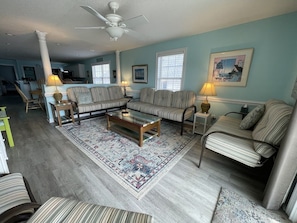 A living room with striped sofas, a coffee table, and a patterned rug.