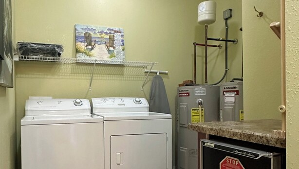 Une buanderie équipée de deux lave-linge à chargement frontal, d’un sèche-linge et d’un chauffe-eau ProMax.