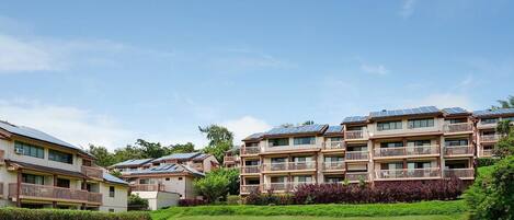 A residential complex with multiple apartment buildings, each featuring balconies and solar panels on the roofs.