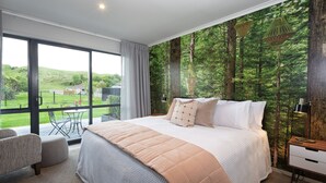 Une chambre avec un grand lit, une vue sur l’extérieur et un balcon.