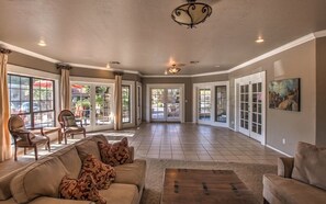 Un salon spacieux avec un canapé beige, une table basse et un lustre.