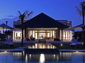 Un resort moderno con piscina, zona de estar al aire libre y una entrada bien iluminada.