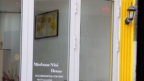 Un edificio amarillo con puerta de cristal que indica 
