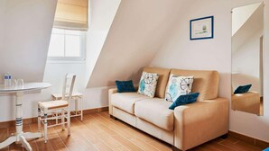 A room with a sofa, two chairs, a small table, and a window with a blind. - Domaine Les Saules (Favieres)
