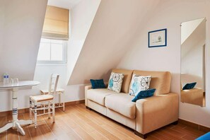 A room with a sofa, two chairs, a small table, and a window with a blind. - Domaine Les Saules (Favieres)