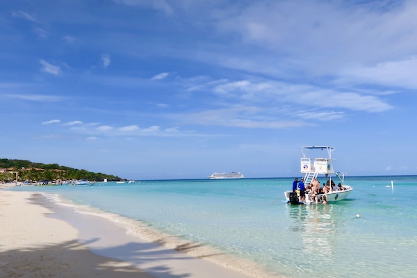 On the beach, white sand, sun-loungers, beach umbrellas