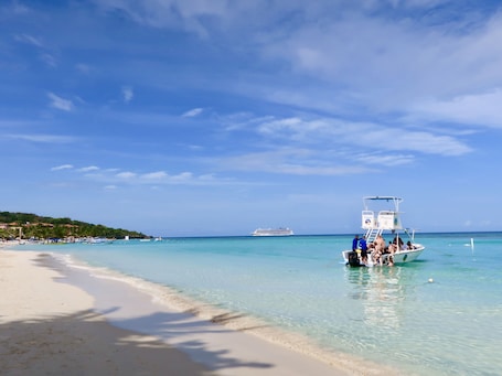 On the beach, white sand, sun loungers, beach umbrellas
