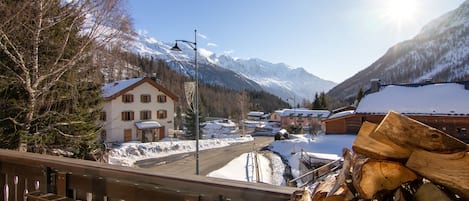 Un village de montagne enneigé, avec des bâtiments traditionnels et un ciel dégagé.