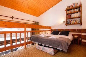 A bedroom with a wooden bunk bed, a bookshelf, and a view of the outside. - Les Soldanelles, Le Tour (Argentière), France (Le Tour (Argentière))