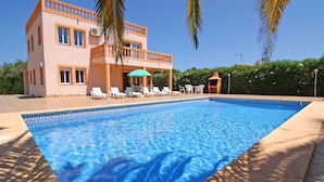A swimming pool with lounge chairs and a two-story building with balconies. - Wonderful private villa for 11 people with private pool, A/C, WIFI, TV, terrace and pets allowed (Benissa)