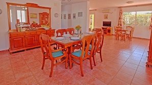 A spacious dining area with a wooden table and chairs, a large mirror, and a chandelier. - Wonderful private villa for 11 people with private pool, A/C, WIFI, TV, terrace and pets allowed (Benissa)