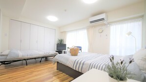 A room with a bed, a small table, a TV, and a wardrobe.