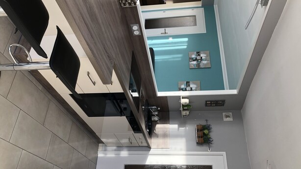Una cocina moderna con horno empotrado, pileta y ventana sobre la encimera.