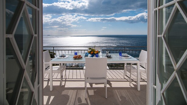 Ein Balkon mit Tisch für Zwei, mit Blick auf das Meer.