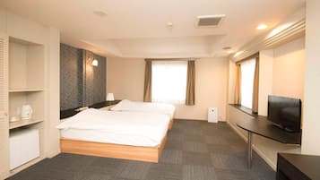 Habitación de hotel con cama doble, televisión de pantalla plana, cafetera y un pequeño calentador.